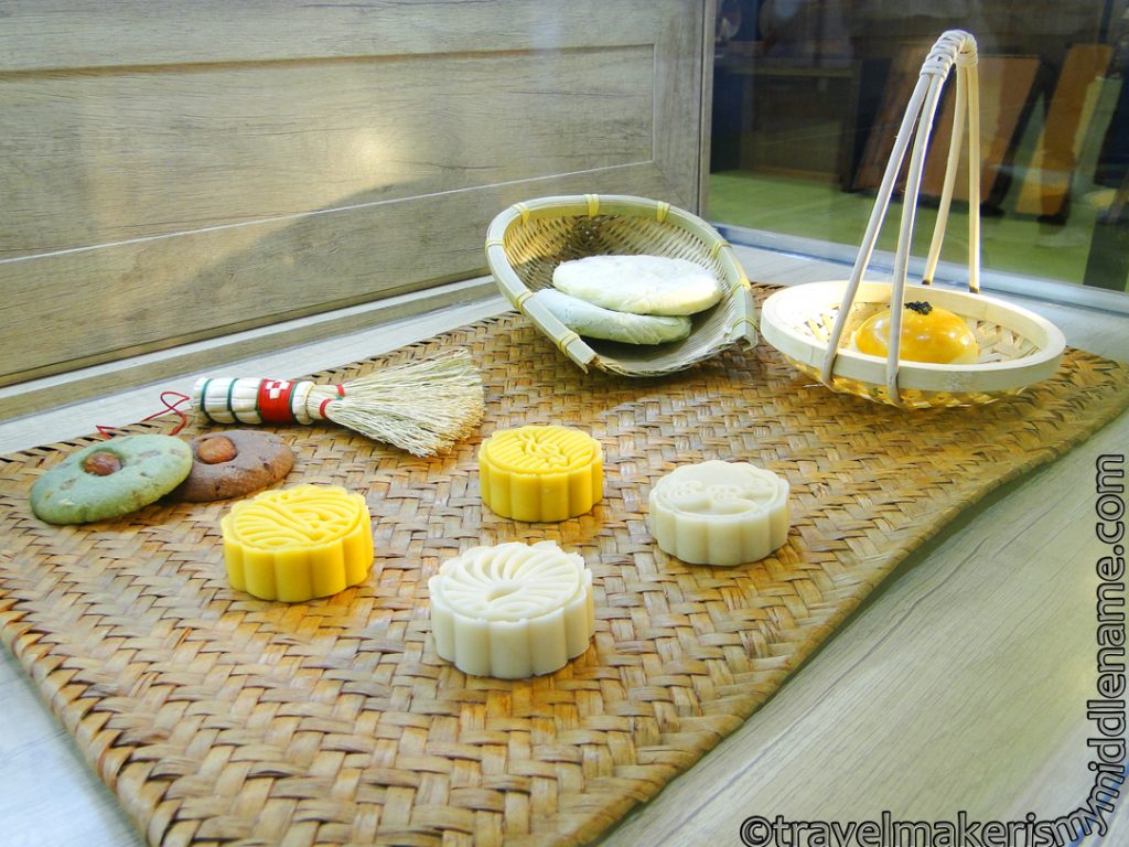 Yellow and white Chinese tea pastries on display on a bamboo matt and basket at the Spring Xiamen Tea Fair. 