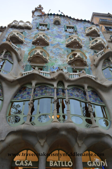 The blue tiled facade of Casa Batlo in Barcelona, Spain seen from the street.