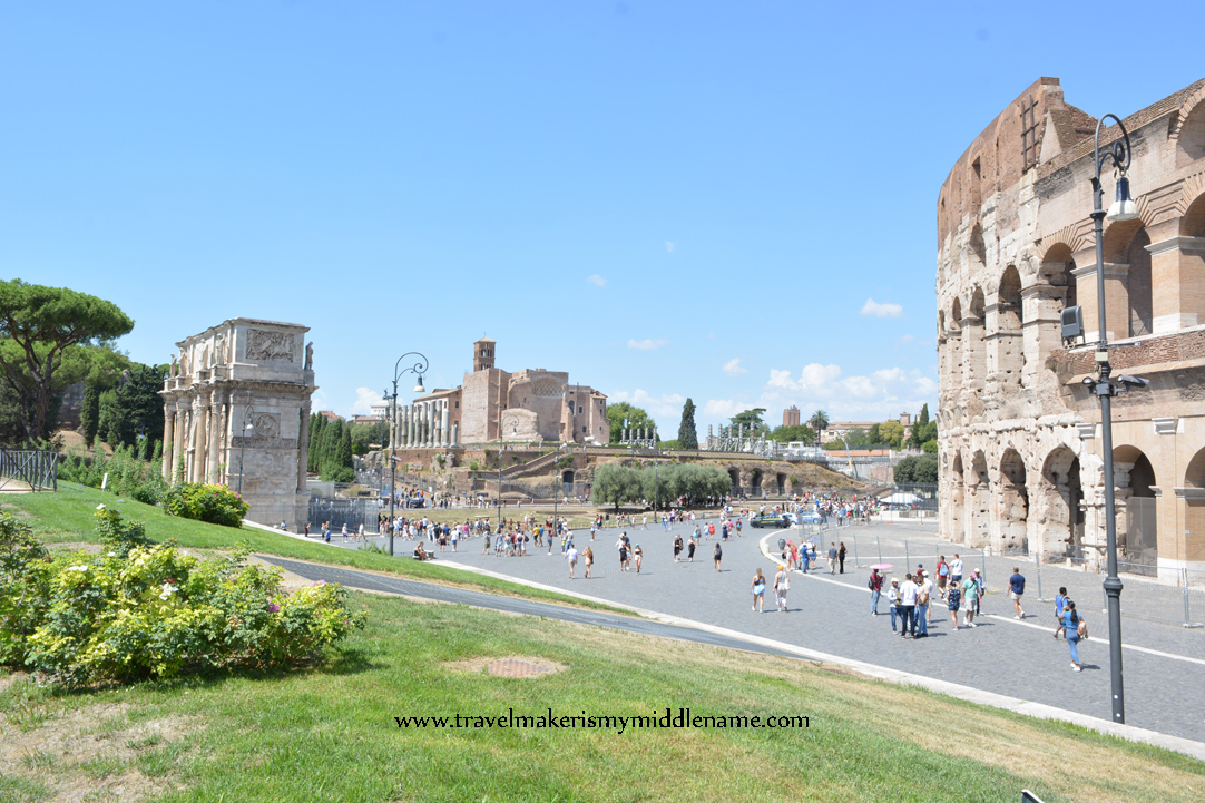 Wide shot of the Colosseum on the right, Velian Hill in the center, and Arch of Constantine on the left in Rome, Italy.