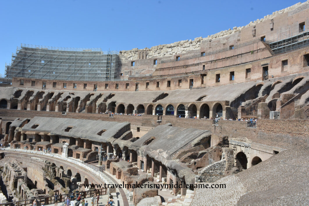 Inside the Colosseum in Rome, Italy showing the stadium against a cloudless blue summer sky.