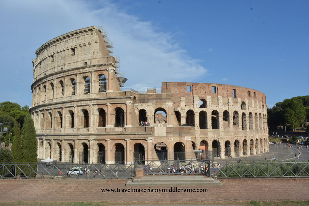 A front view of the Colosseum in Rome, Italy during the day with a blue sky.