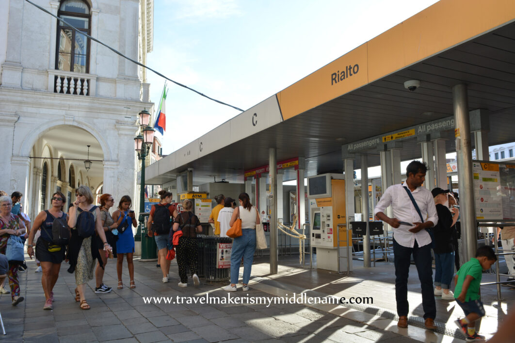 People outside during the day at a ferry ticket booth in Venice, Italy.