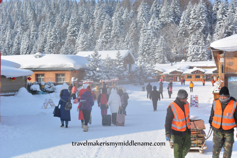 Tourists walk through Snow Town and workers pull a sled of equipment. Photo credit: Author