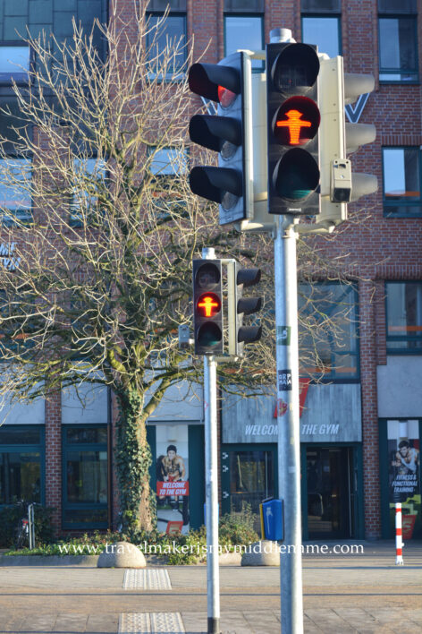 The red Ampelmänchen is a silhouette of a man seen from the front with a hat, feet together and arms outstretched to either side, to indicate to the pedestrian to stop.