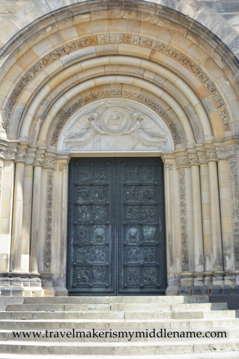 The light coloured stone arch and metal door of the St Petri cathedral of Bremen, Germany