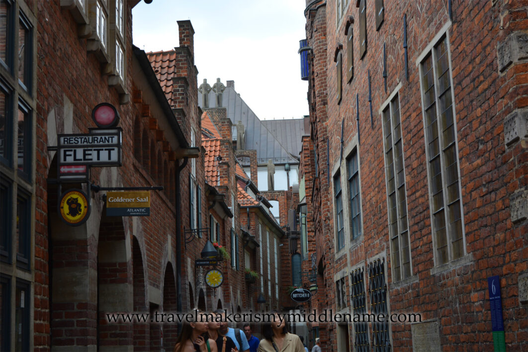 Red brick buildings on either side in a narrow street in Böttcherstraße, (Böttcher Street) Bremen, Germany.